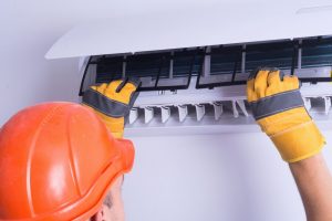man replacing air conditioner filter
